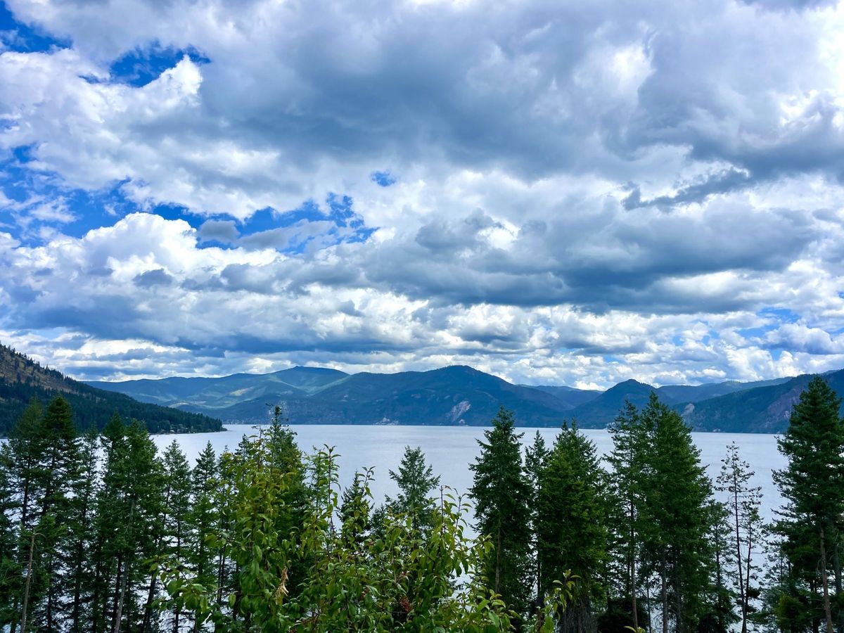 Lake Pend Oreille and forested North Idaho mountains under a dramatic sky